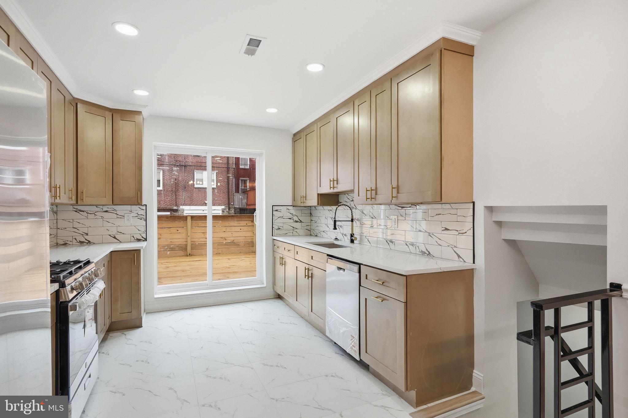 7413 Sommers Road Philadelphia, PA 19138 - Photo 12 of 54 a kitchen with stainless steel appliances granite countertop a stove and a sink