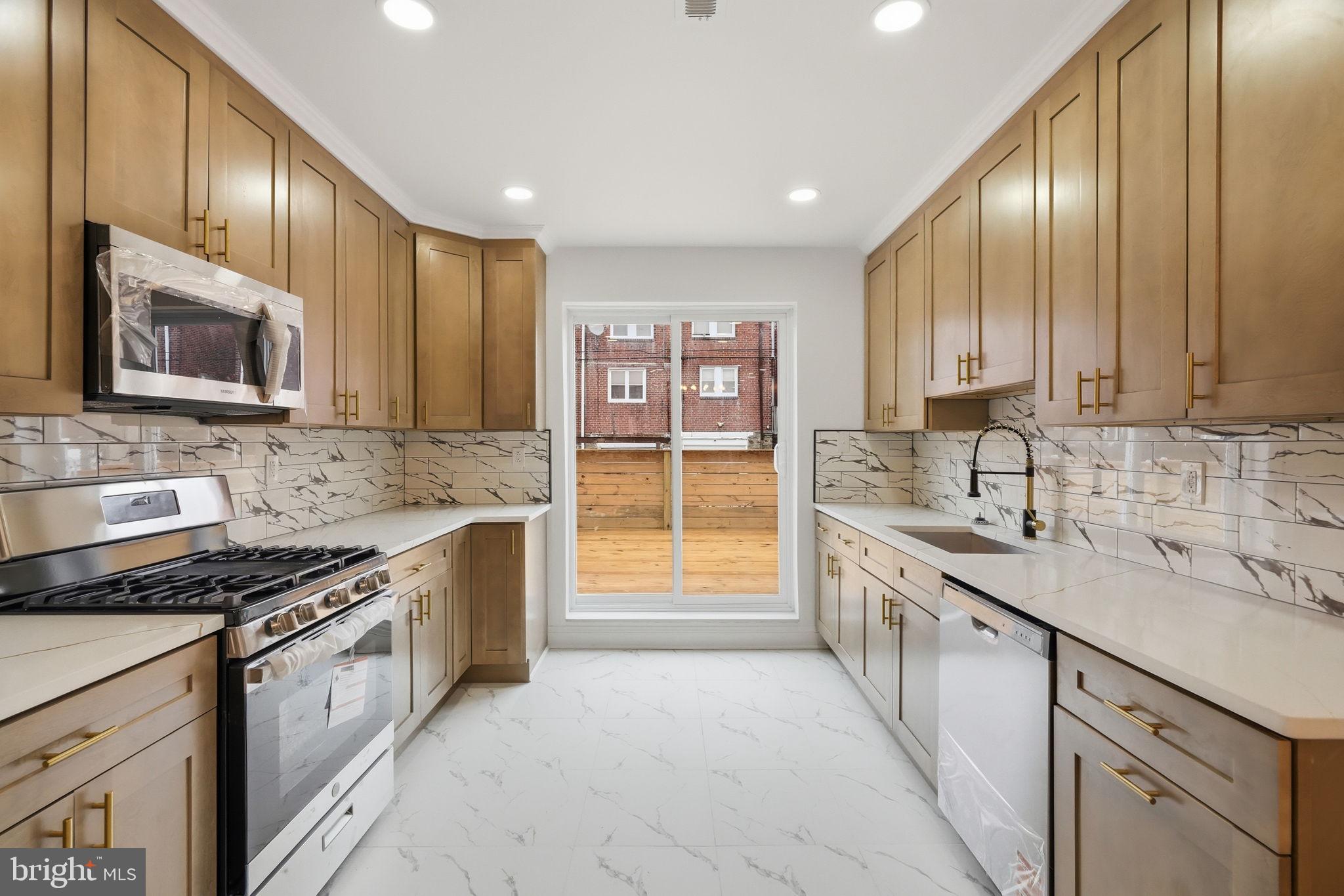 7413 Sommers Road Philadelphia, PA 19138 - Photo 13 of 54 a large kitchen with stainless steel appliances granite countertop a stove sink and cabinets