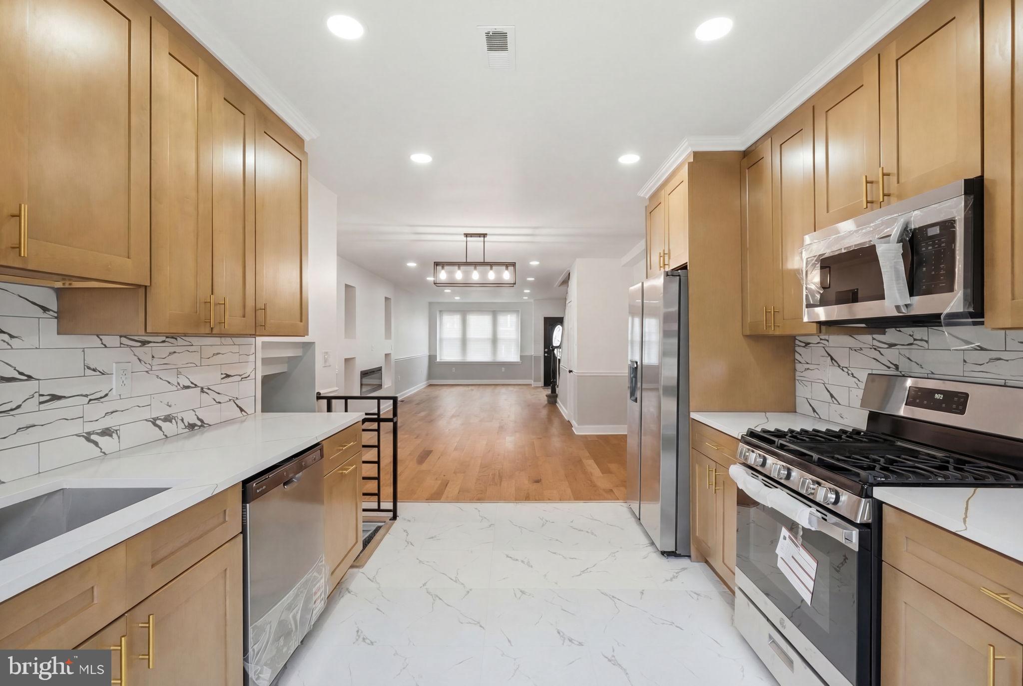 7413 Sommers Road Philadelphia, PA 19138 - Photo 14 of 54 a kitchen with stainless steel appliances a sink stove and refrigerator