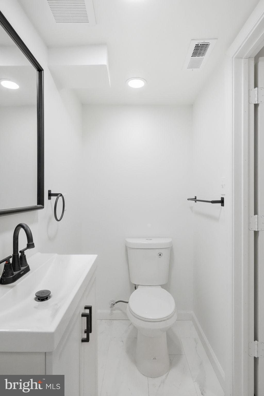 7413 Sommers Road Philadelphia, PA 19138 - Photo 32 of 54 a bathroom with a toilet a sink and mirror