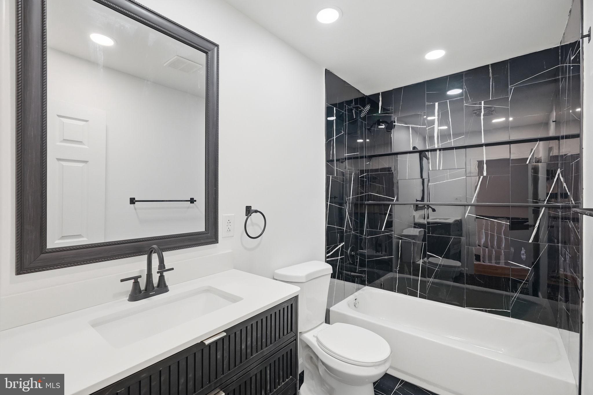 7413 Sommers Road Philadelphia, PA 19138 - Photo 43 of 54 a bathroom with a bathtub shower sink vanity mirror and toilet