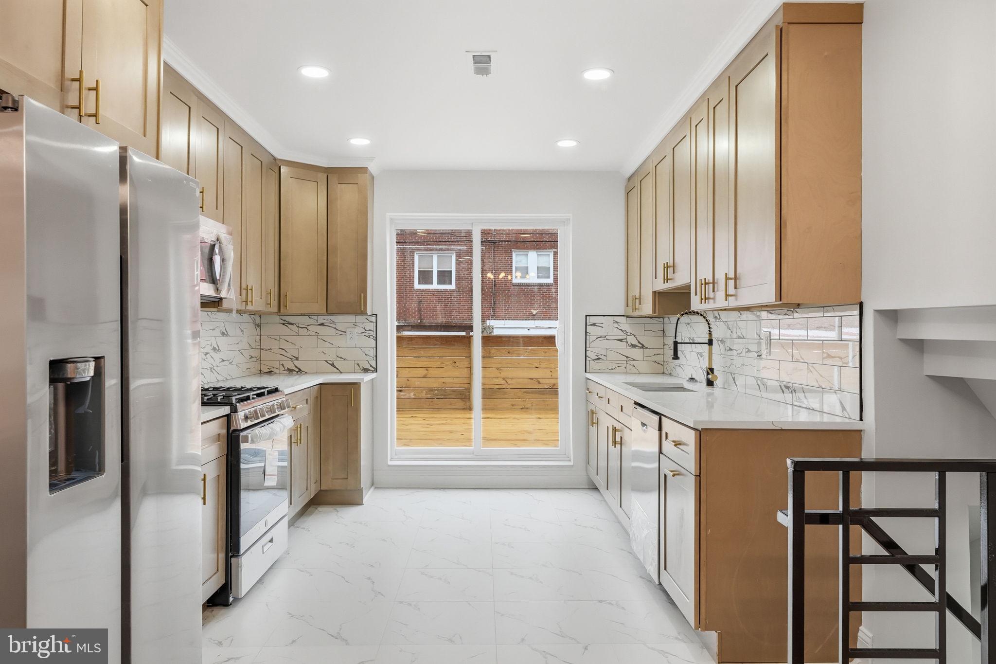7413 Sommers Road Philadelphia, PA 19138 - Photo 10 of 54 a kitchen with stainless steel appliances granite countertop a stove top oven a sink and a refrigerator