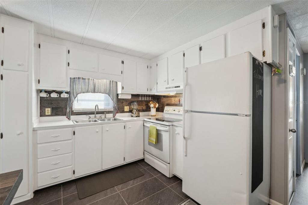 1600 Old Coachman Rd., Unit 709 Clearwater, FL 33765 - Photo 13 of 23 a kitchen with white cabinets and white appliances