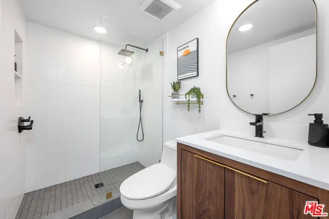 a bathroom with a granite countertop toilet sink and mirror