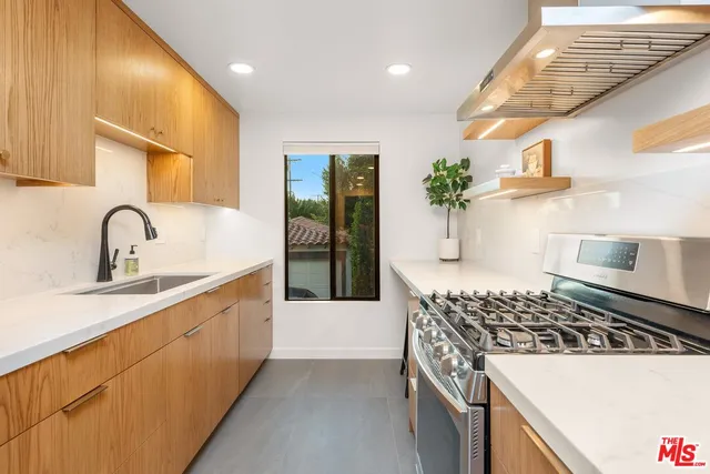 a kitchen with stainless steel appliances granite countertop a sink stove and cabinets