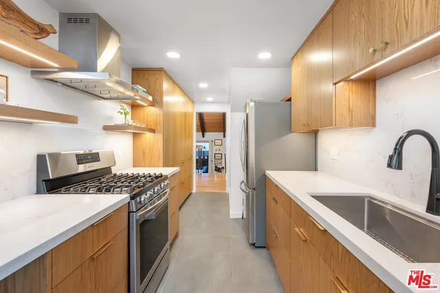 a kitchen with stainless steel appliances kitchen island a large stove a sink dishwasher and refrigerator with wooden floor