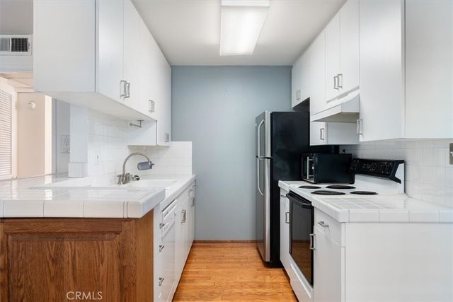 a kitchen with stainless steel appliances a stove a sink and a refrigerator