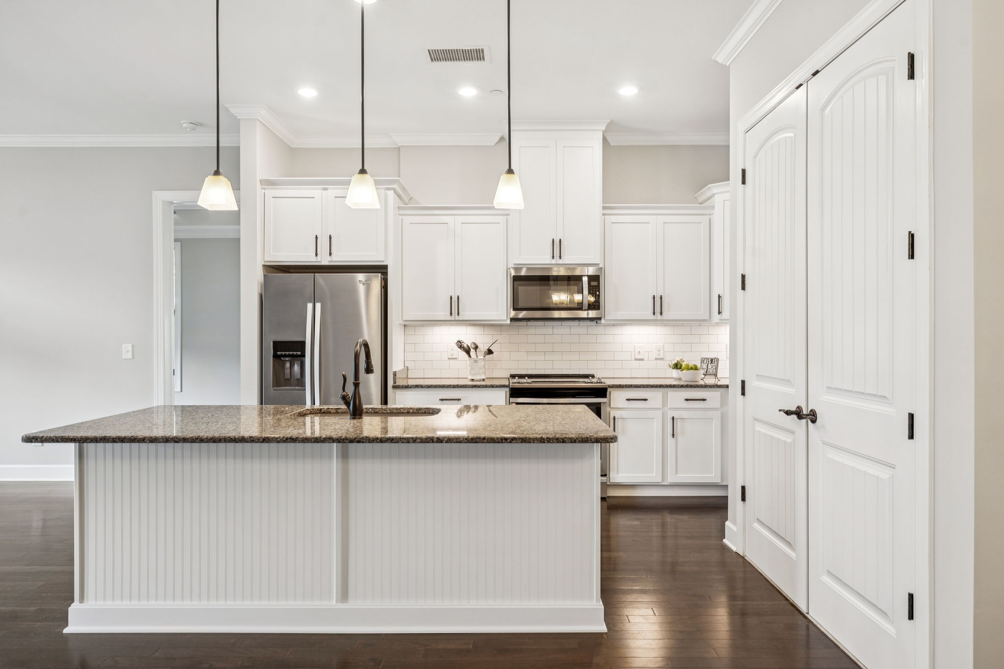 201 Swain Circle, Unit 104 Franklin, TN 37064 - Photo 8 of 45 a kitchen with stainless steel appliances granite countertop a refrigerator a sink dishwasher a stove and white cabinets with wooden floor