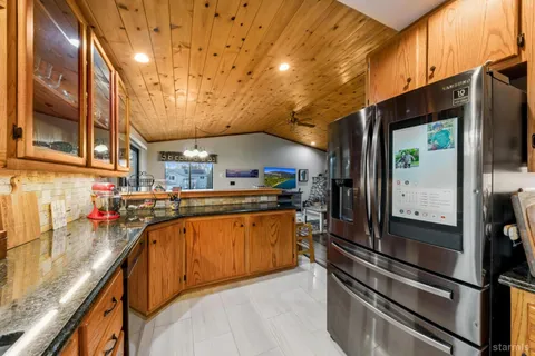 a kitchen with stainless steel appliances granite countertop a sink a stove and a refrigerator