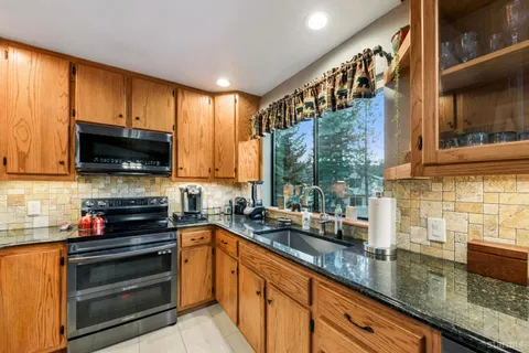 a kitchen with stainless steel appliances a stove sink microwave and cabinets