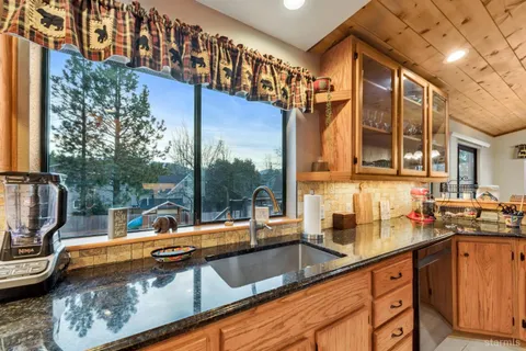 a view of a sink and dishwasher with wooden floor