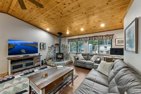 a living room with furniture a flat screen tv and a floor to ceiling window