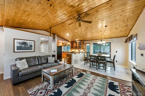 a living room with furniture a wooden floor and next to a window