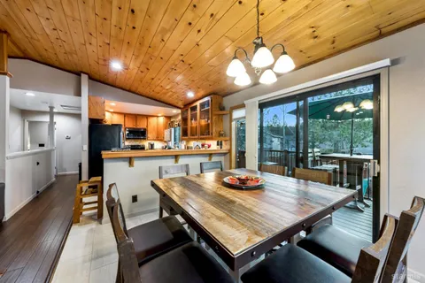 a view of a dining room with furniture a chandelier and wooden floor