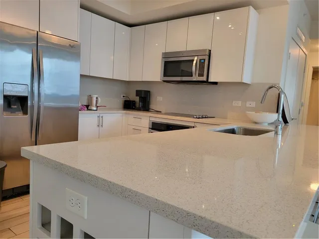 a kitchen with stainless steel appliances a stove microwave sink and refrigerator