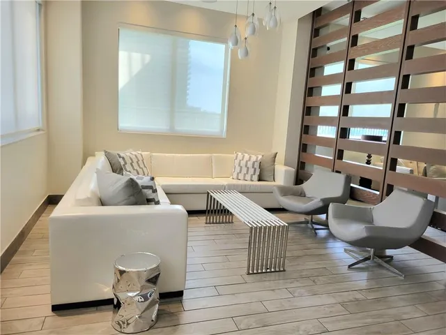 a living room with furniture and a potted plant