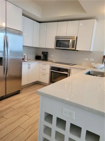 a kitchen with a sink a microwave and cabinets