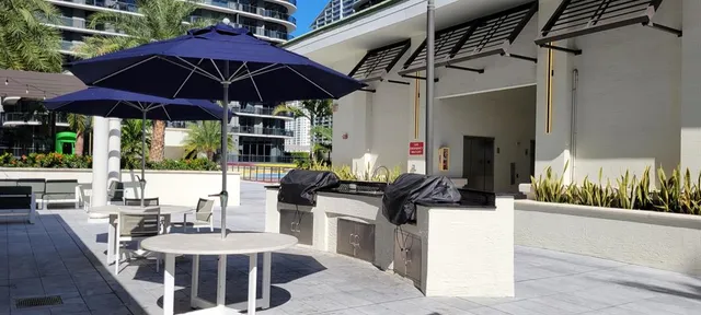 a view of a patio with couches table and chairs under an umbrella