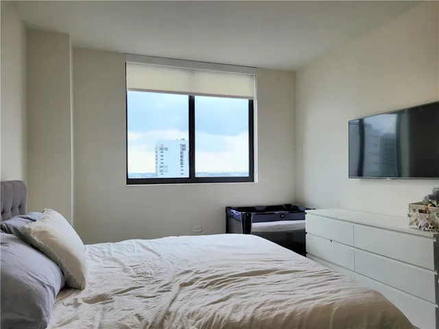 a bedroom with a bed and a flat screen tv