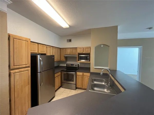 a kitchen with stainless steel appliances granite countertop a refrigerator and a sink