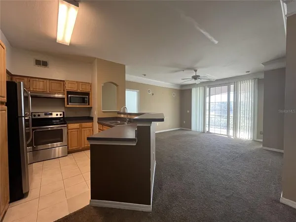 a kitchen with kitchen island a counter top space stainless steel appliances and a window