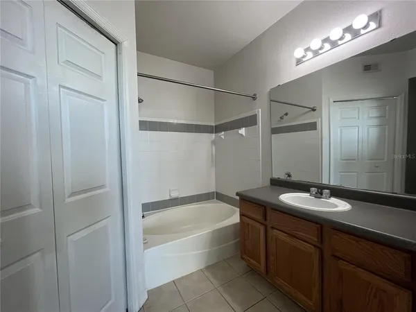 a bathroom with a granite countertop sink tub and a mirror