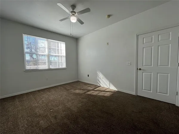 a view of empty room with ceiling fan