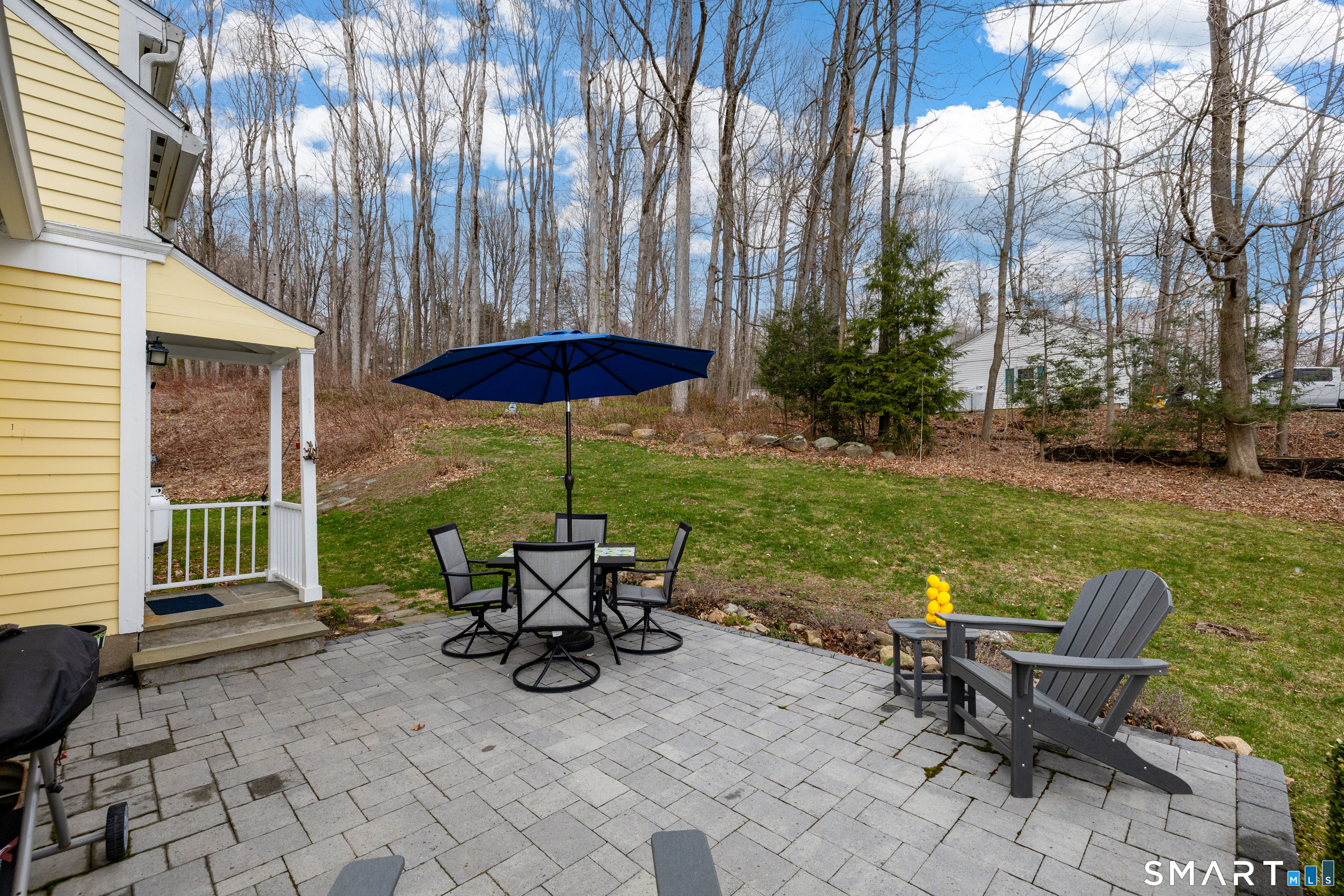 11 Sheldon Lane Litchfield, CT 06759 - Photo 27 of 33 a view of a patio with table and chairs under an umbrella with a small yard