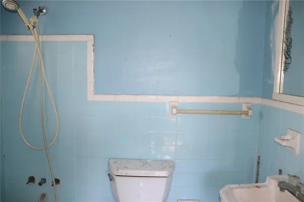 a white toilet sitting next to a shower
