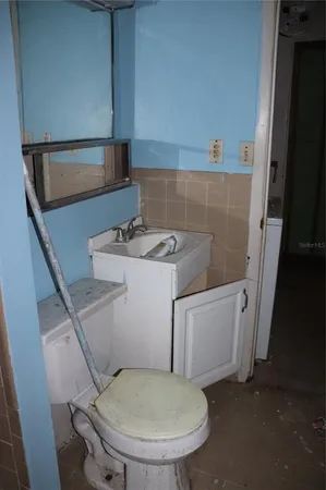 a bathroom with a sink toilet and mirror