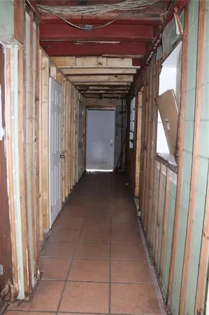 a view of a hallway with wooden walls and door