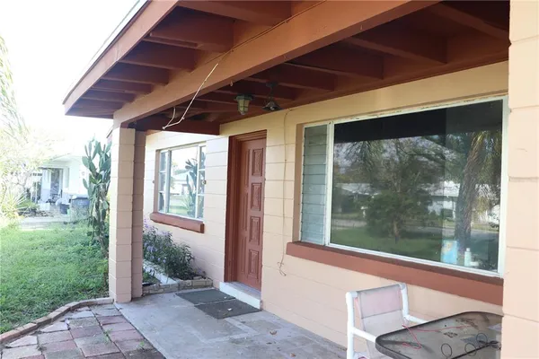 a porch with a table and chairs in front of it