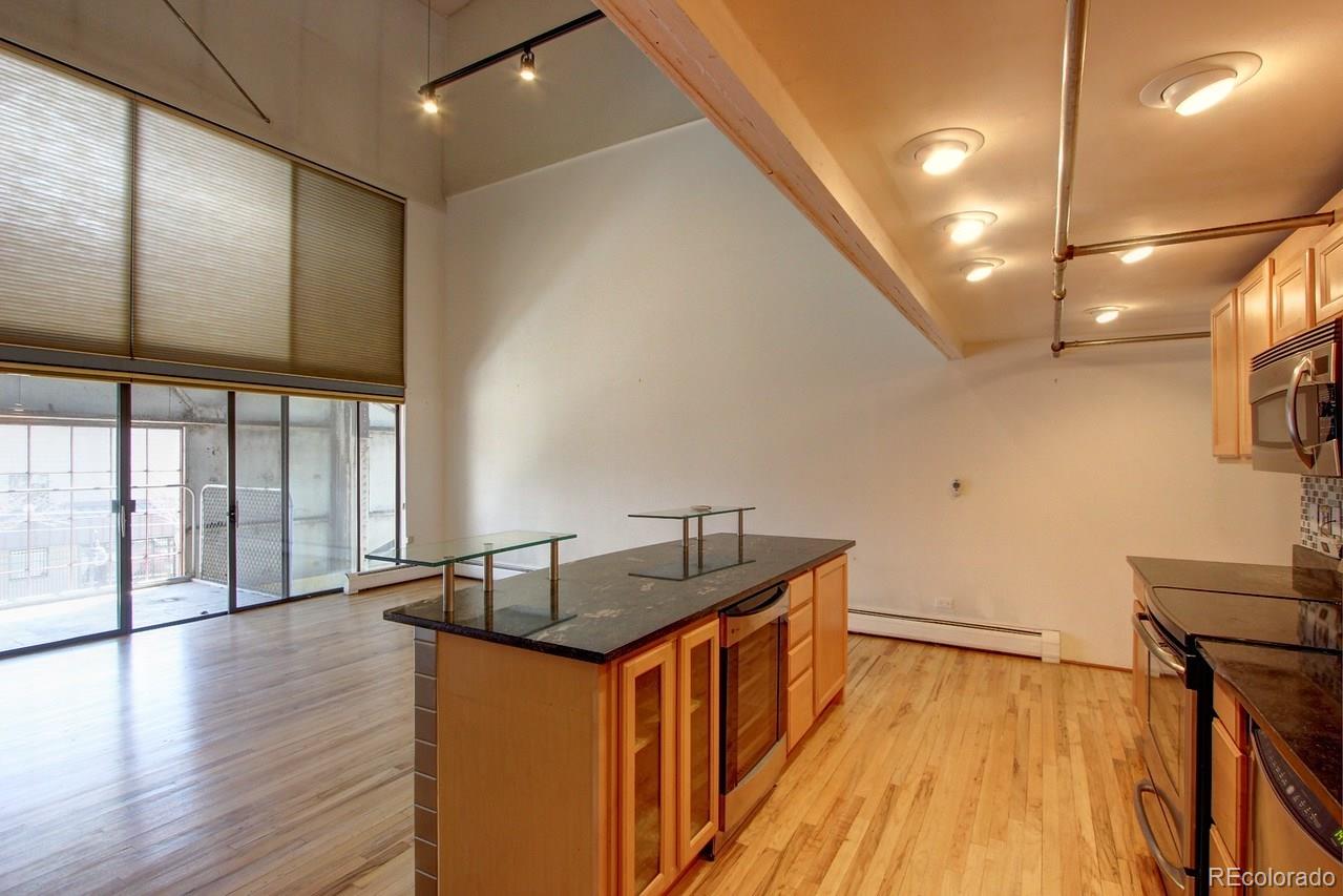 3377 Blake Street, Unit 202 Denver, CO 80205 - Photo 15 of 19 a kitchen with counter top space and wooden floor