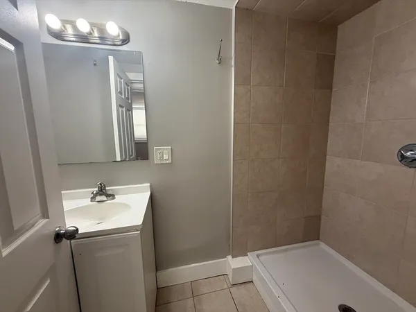 a bathroom with a sink a mirror and shower