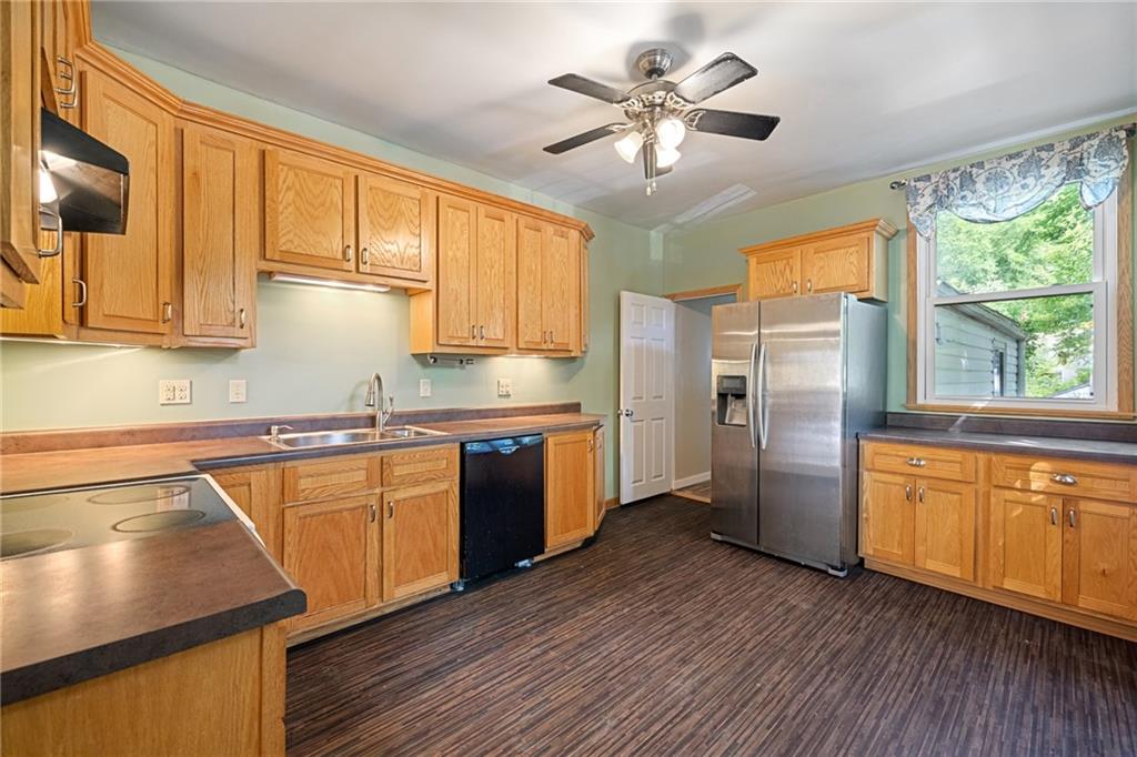 127 Fountain Street Pittsburgh, PA 15212 - Photo 6 of 25 a kitchen with stainless steel appliances granite countertop a refrigerator a sink dishwasher a stove and white countertops with wooden floor