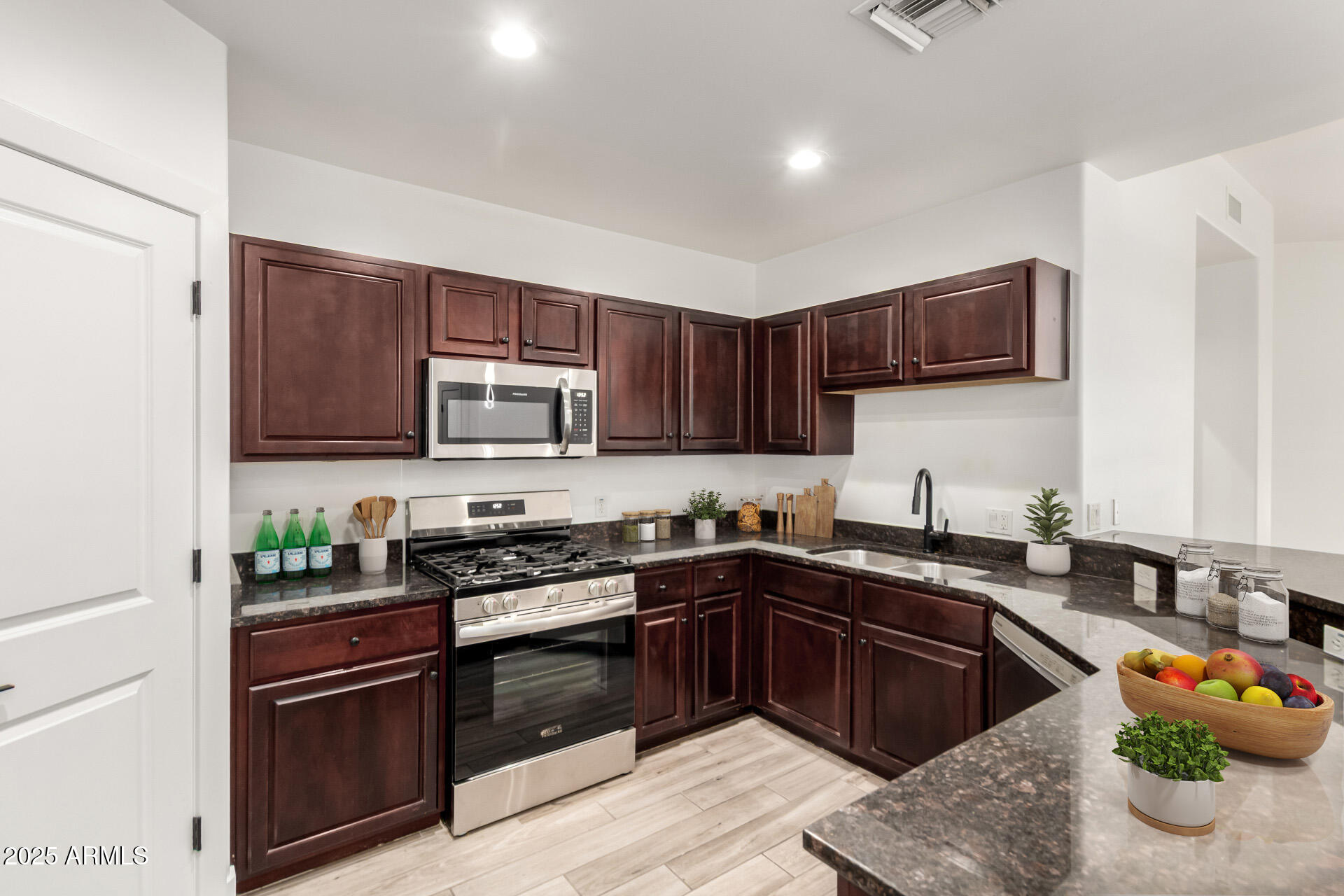 945 East Playa Del Norte Drive, Unit 4020 Tempe, AZ 85288 - Photo 11 of 39 a kitchen with stainless steel appliances granite countertop a stove a sink dishwasher and a microwave oven with wooden cabinets
