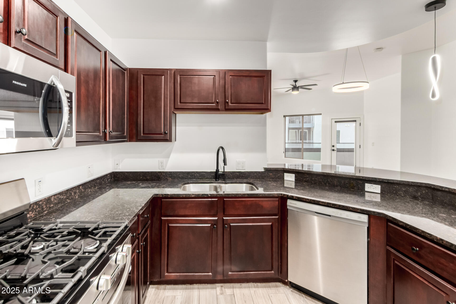 945 East Playa Del Norte Drive, Unit 4020 Tempe, AZ 85288 - Photo 13 of 39 a kitchen with stainless steel appliances granite countertop a sink stove and microwave