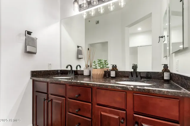 a bathroom with double sink and a mirror