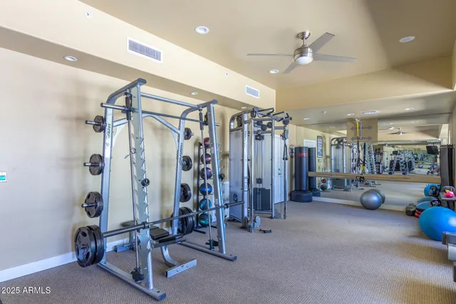 a living room with furniture gym equipment and a large window