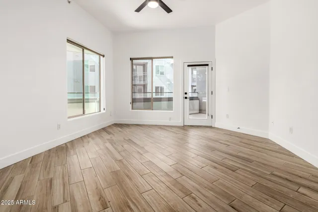 an empty room with wooden floor and windows