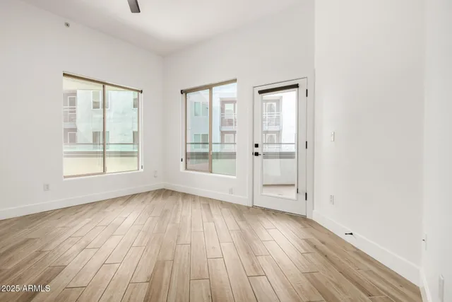 an empty room with wooden floor and windows