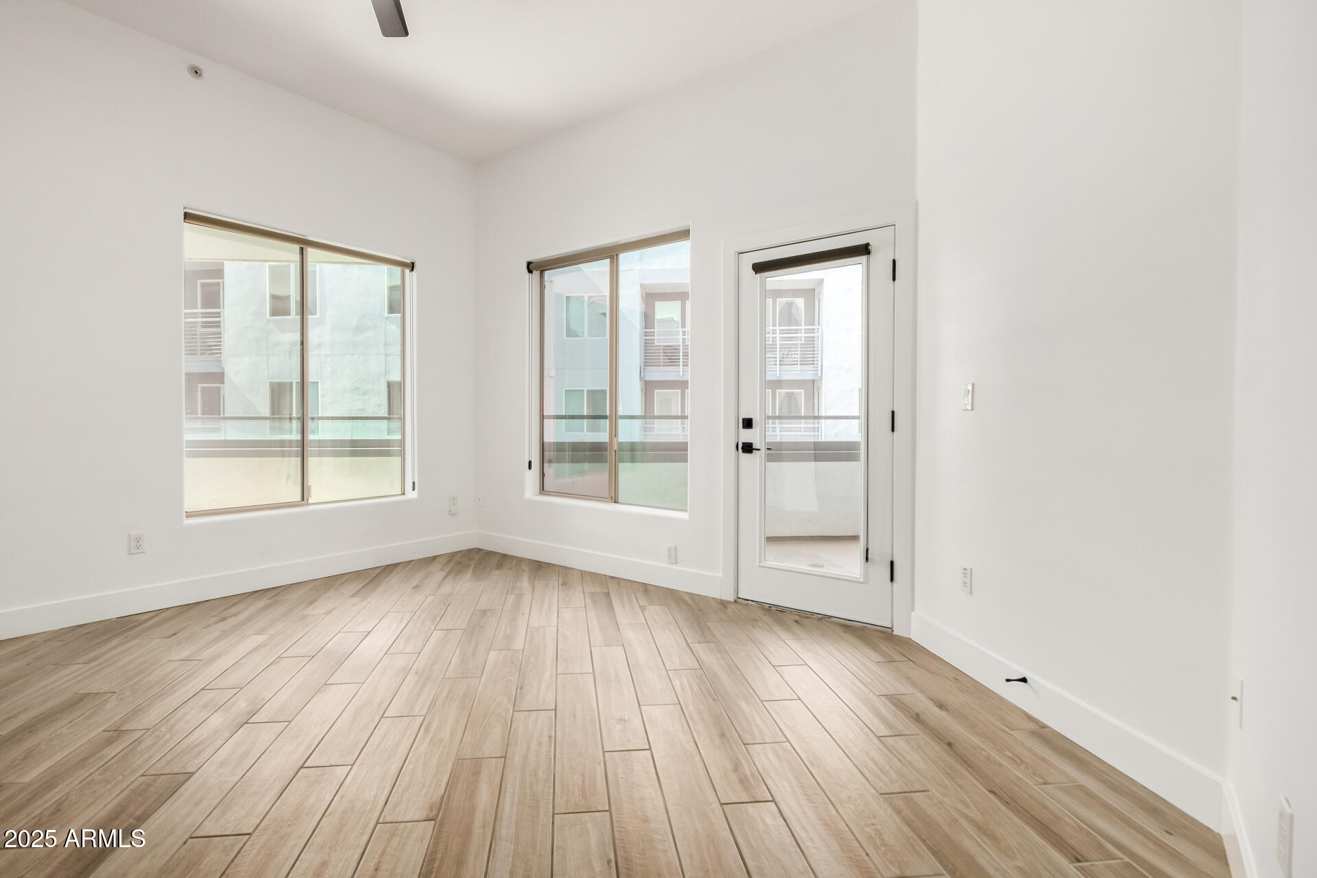 945 East Playa Del Norte Drive, Unit 4020 Tempe, AZ 85288 - Photo 8 of 39 an empty room with wooden floor and windows