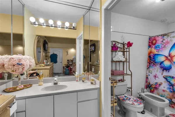 a bathroom with a sink a toilet and shower a mirror