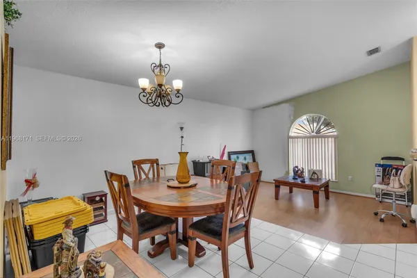 a view of a dining room with furniture and a chandelier