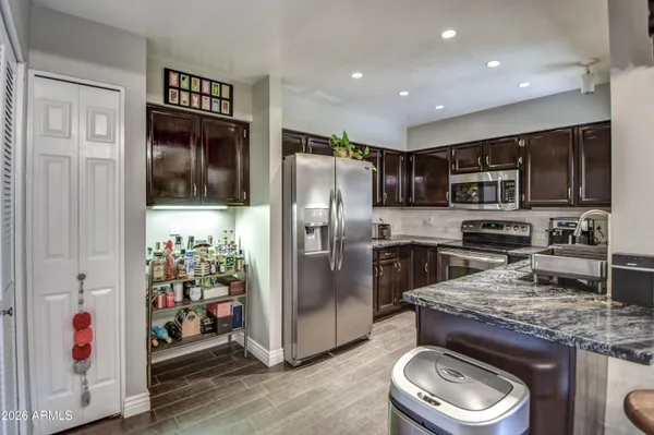 a kitchen with stainless steel appliances granite countertop a refrigerator a stove a sink and a microwave
