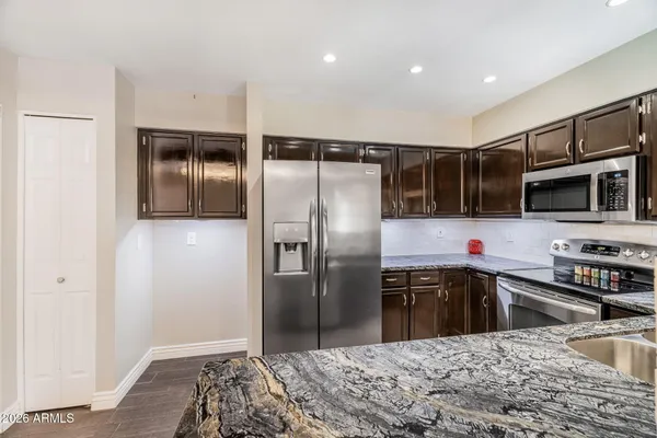 a kitchen with granite countertop a refrigerator and a sink
