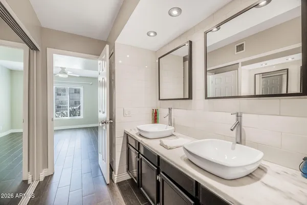 a bathroom with a granite countertop sink a toilet and mirror