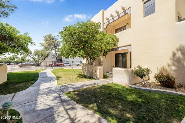 a view of a white house with a yard and plants