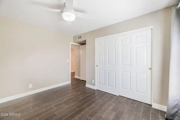 an empty room with wooden floor and windows