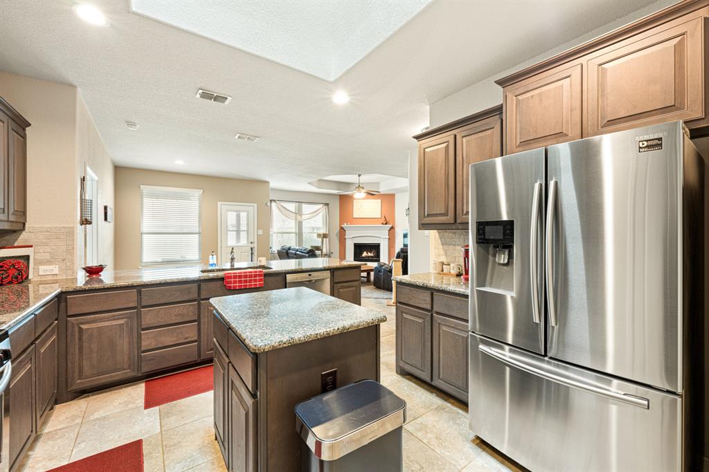 916 Falcon Road Argyle, TX 76226 - Photo 14 of 37 Kitchen with stainless steel appliances, kitchen peninsula, a kitchen island, and backsplash
